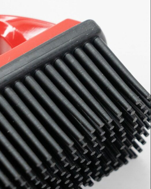 Close-up of a black brush with red handle on a white background
